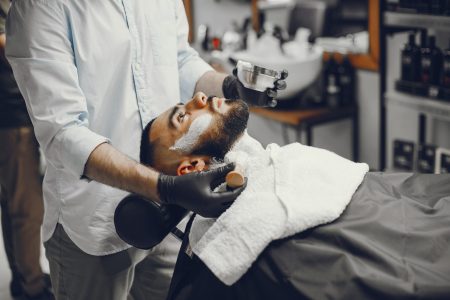 A man in a barbershop. Clipping beard in the barber. Rest in hairdressing salon